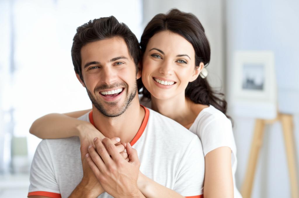 A happy couple smiling and holding hands, looking relaxed and connected, representing renewed intimacy.